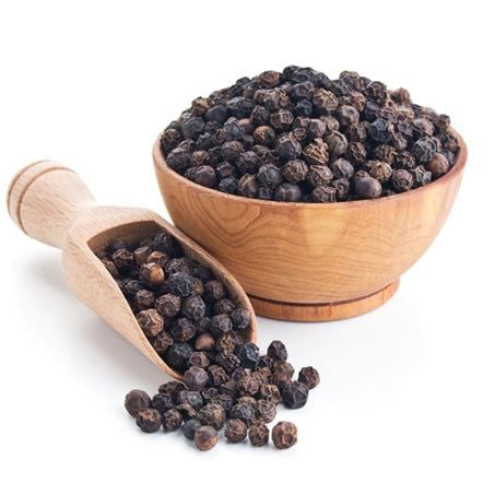 Wooden bowl and scoop filled with black peppercorns on a white background