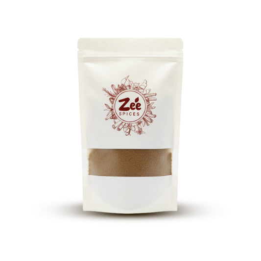 White pouch of Zée Spices with a visible cumin powder mix on a white background